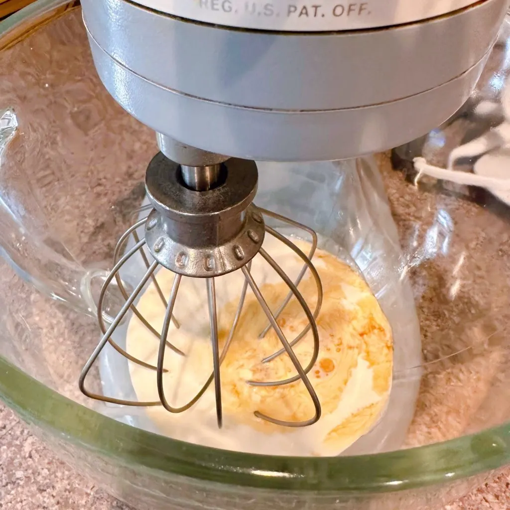 Whipped cream in bowl of mixer.