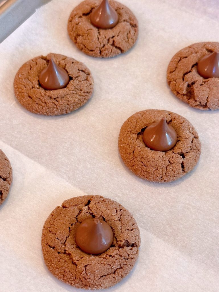 Pressing milk chocolate candy into the top of each cookie.