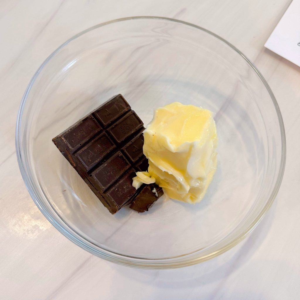 Butter and chocolate squares in a large microwave bowl.