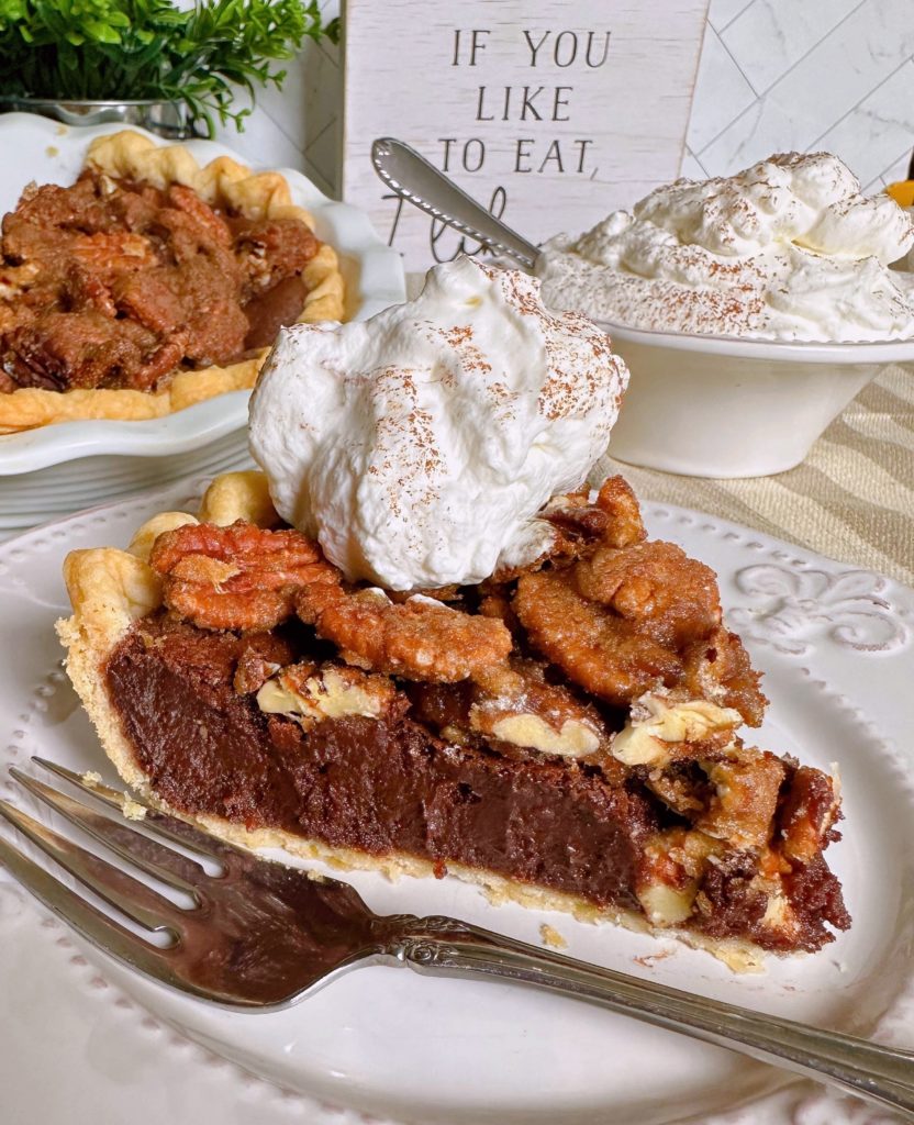 Easy Chocolate Pecan Chess Pie sliced and on a plate with a dollop of whipped cream.