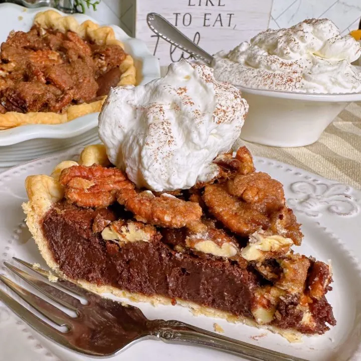 Easy Chocolate Pecan Chess Pie sliced and on a plate with a dollop of whipped cream.