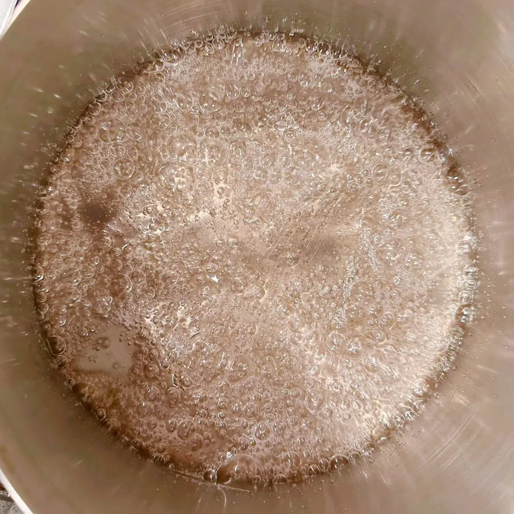 Stage two of the caramel making process. Small bubbles in a sauce pan.