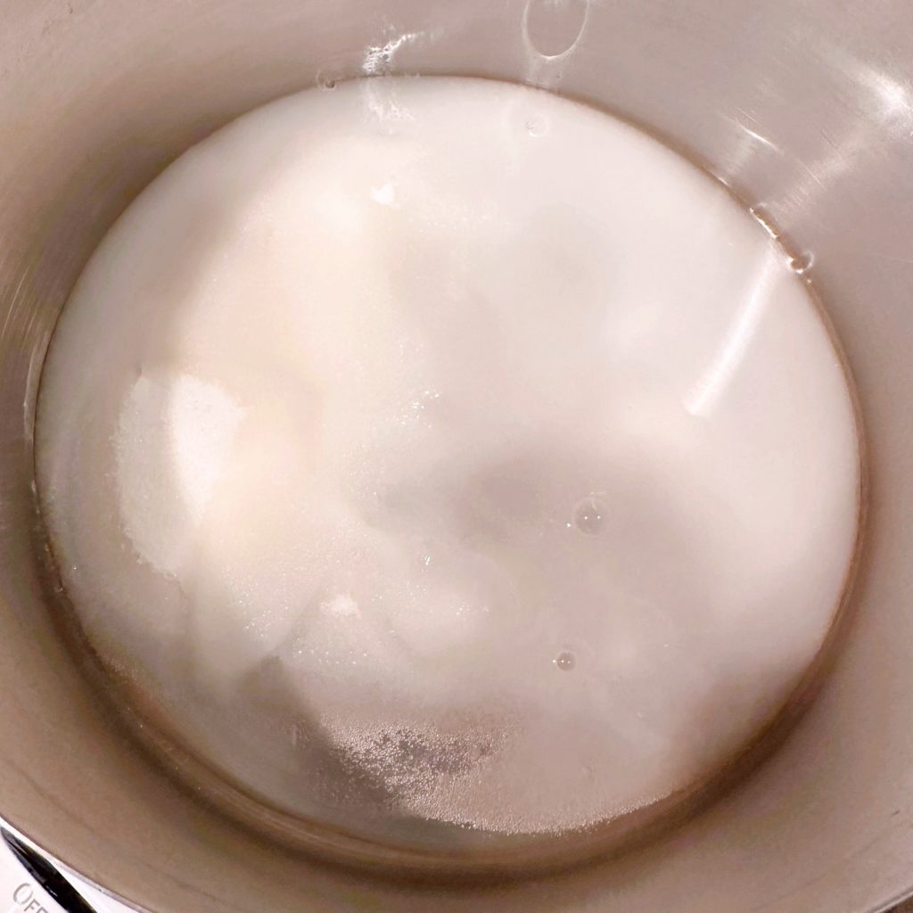 Sauce pan on the stove top with sugar, water and salt. 