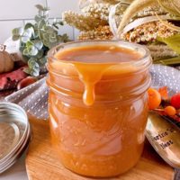 Homemade Salted Caramel sauce with caramel dripping off the edge of the jar.