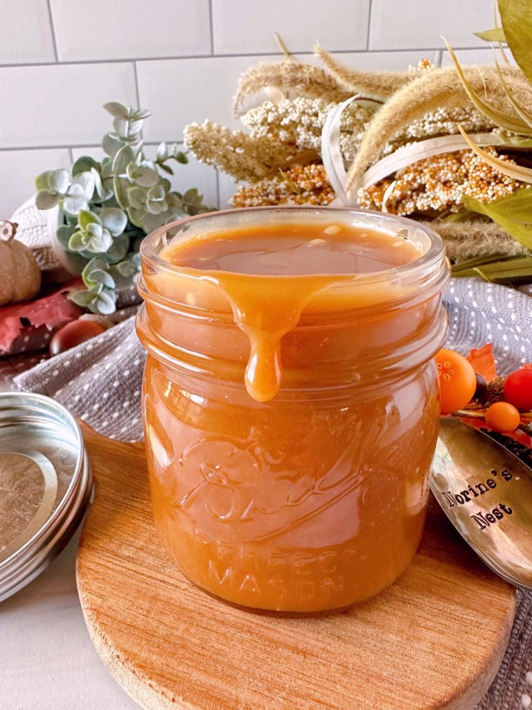 Homemade Salted Caramel sauce with caramel dripping off the edge of the jar.