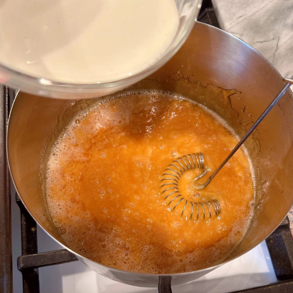 Adding heavy cream to hot buttered sugar mixture.