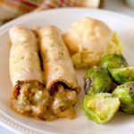 Turkey Rolls with mashed potatoes and gravy on a white dinner plate.