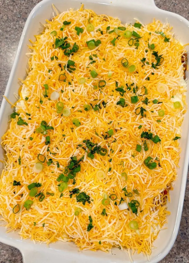 Walking Taco Casserole topped with sliced onions and cilantro.