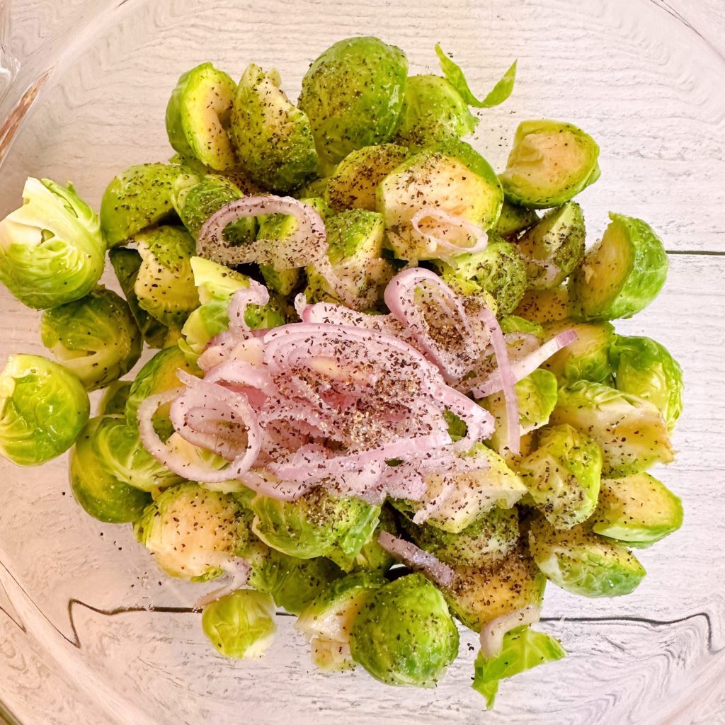Brussels sprouts and shallots in a large bowl.