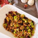 Overhead shot of Roasted Brussels Sprouts with pecans and cranberries in a white serving bowl.