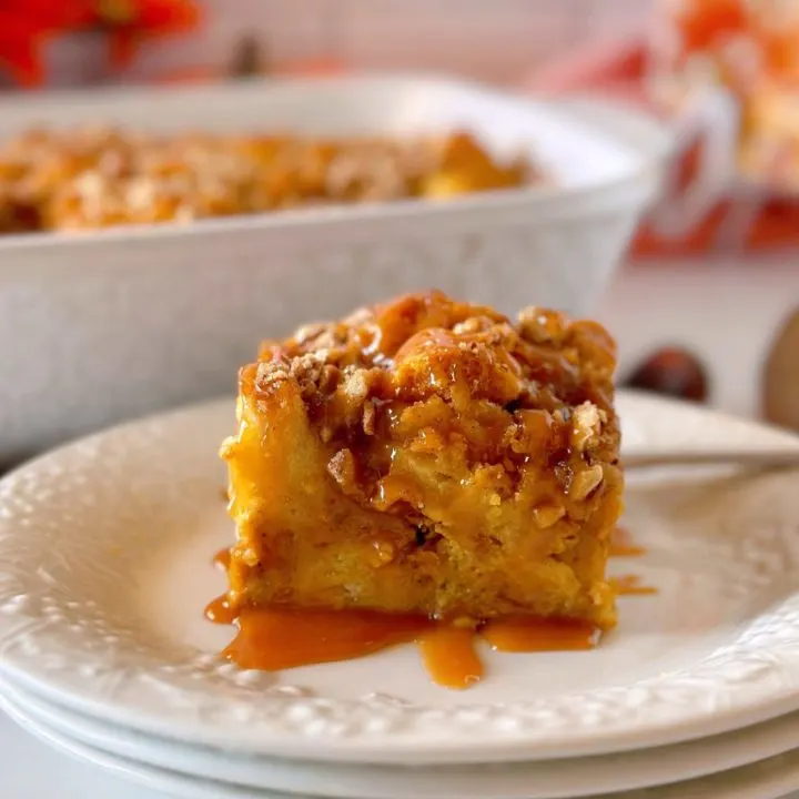 Pumpkin Bread Pudding on dessert plates with the casserole of bread pudding in the background.