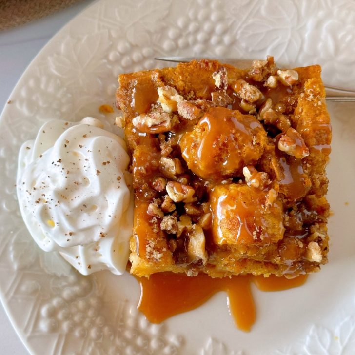 Pumpkin Pecan Bread Pudding with a side of sweetened whipped cream and caramel sauce.