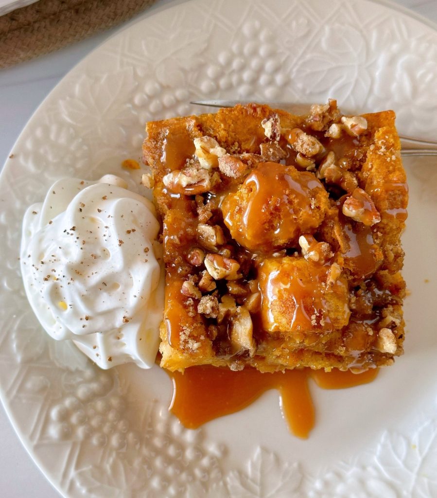 Pumpkin Pecan Bread Pudding with a side of sweetened whipped cream and caramel sauce.