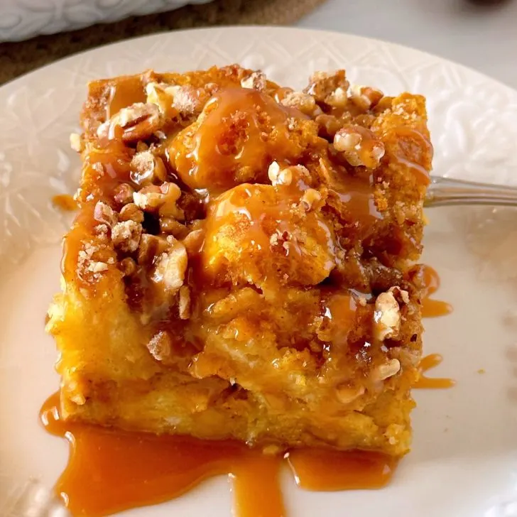 Pumpkin Bread Pudding with caramel sauce on a dessert plate.