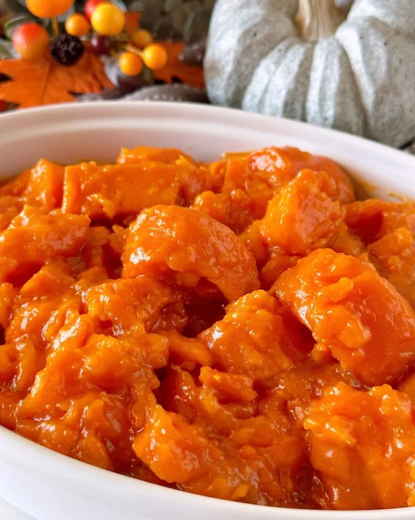 Close-up photo of Candied Yams in a white serving bowl.