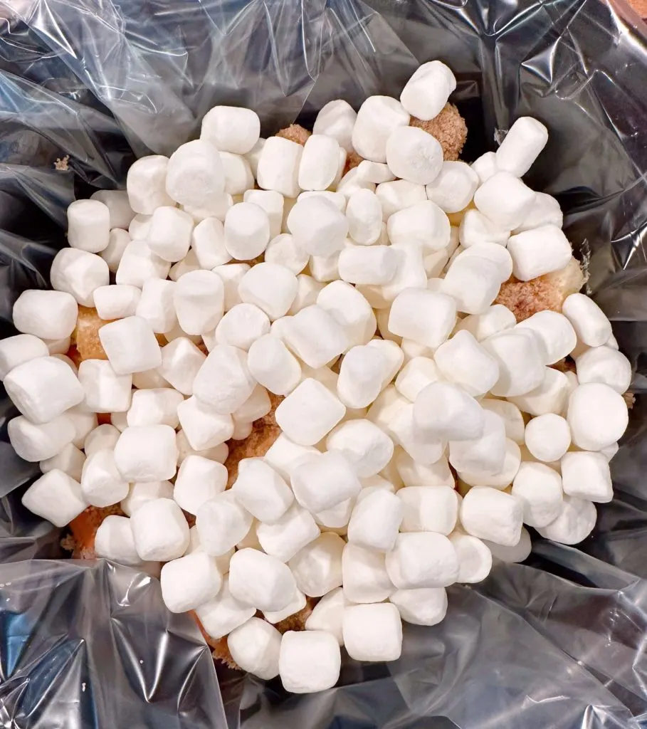 Adding mini-marshmallows to sweet potatoes.