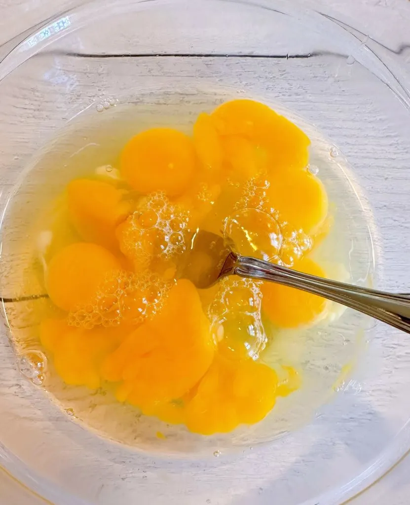 Eggs are cracked and added to a large bowl.