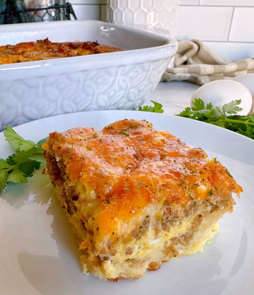 Breakfast Crescent Casserole slice on a white plate with cilantro.