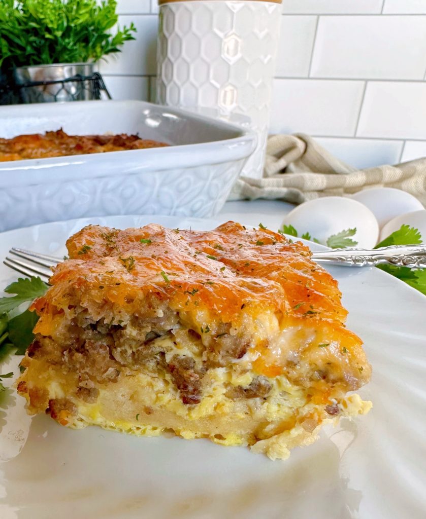 Layered Holiday Crescent Roll Breakfast Casserole serving on a white plate.