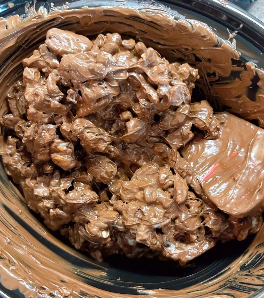 Slow-cooker chocolates are stirred.