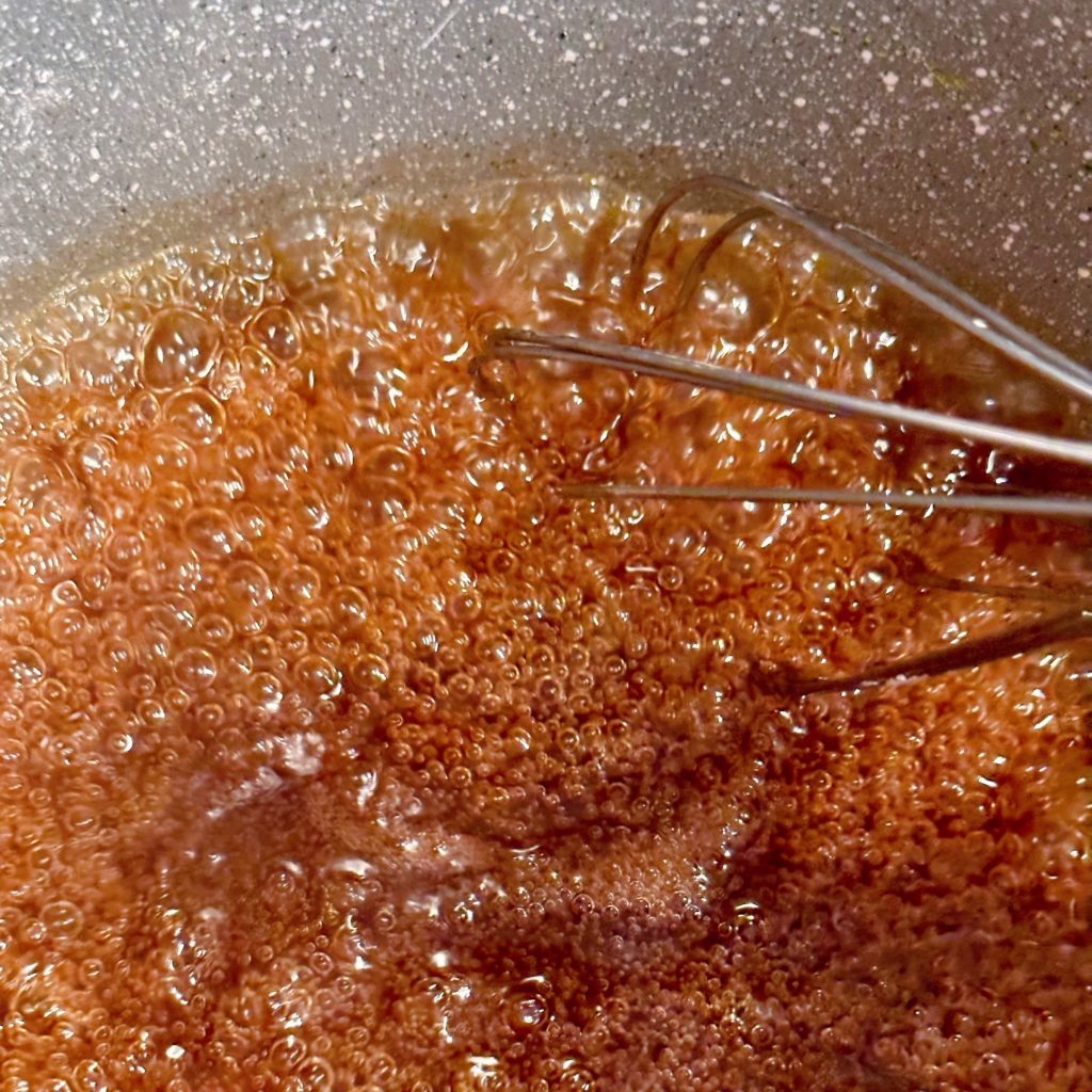 Caramel sauce in pan boiling.