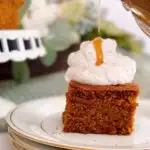 Topping warm gingerbread cake with whipped cream and warm caramel sauce.