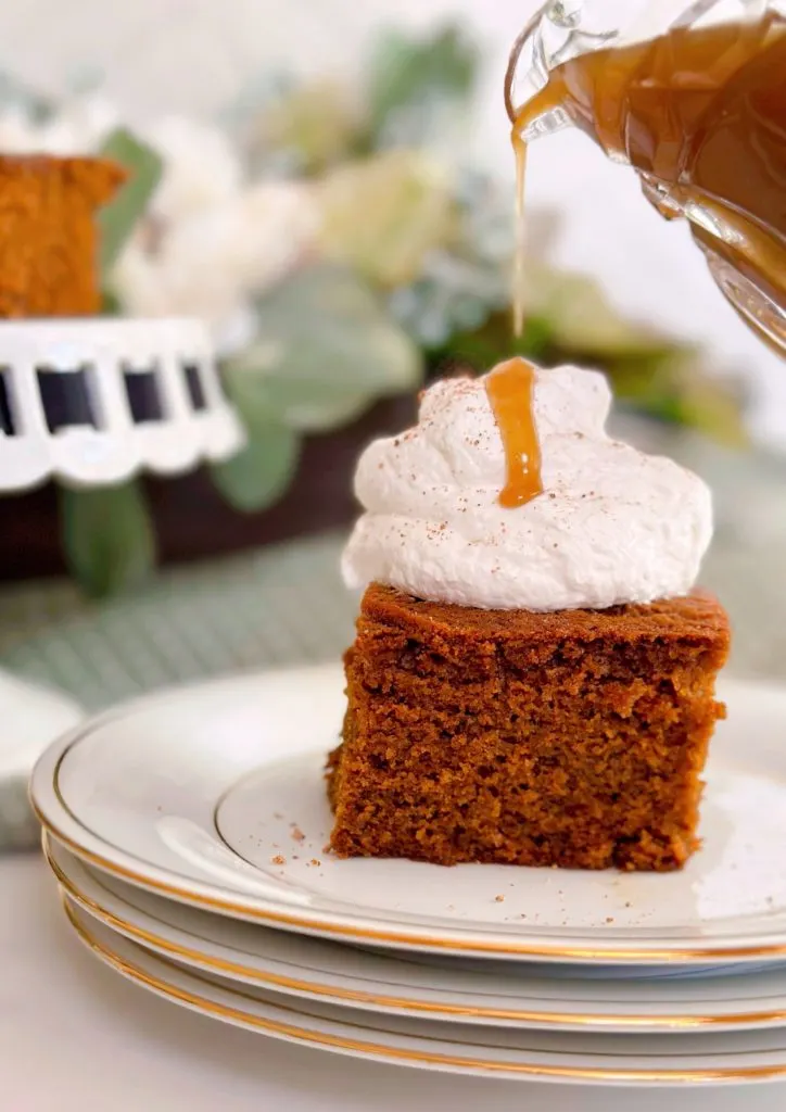 Topping warm gingerbread cake with whipped cream and warm caramel sauce.