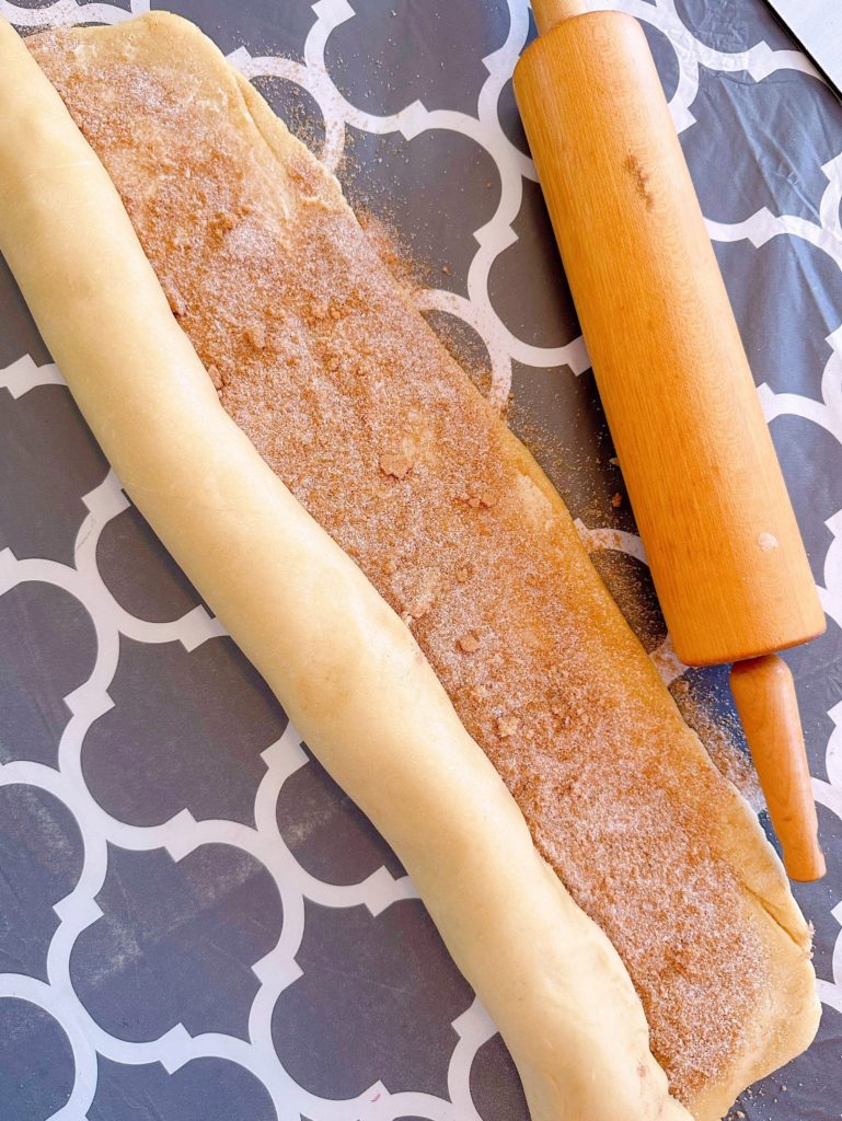 Rolling the sweet bread into a jelly-roll type of roll.