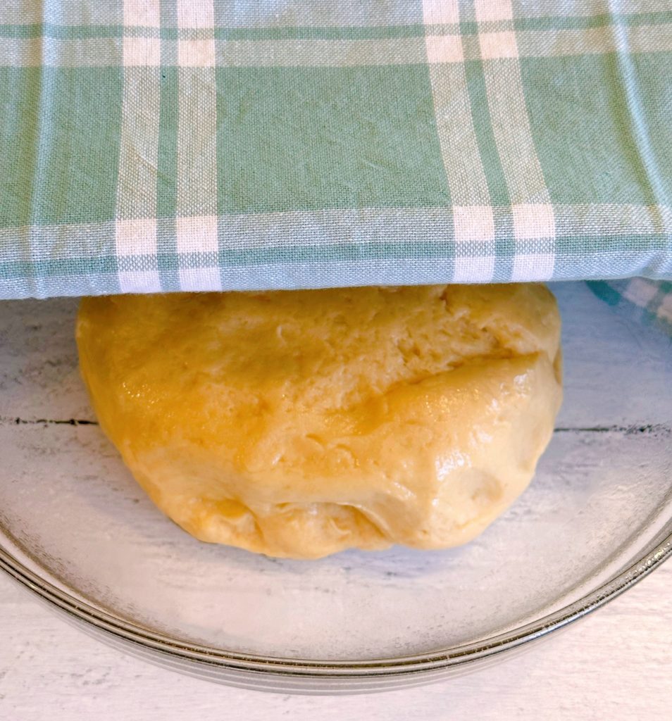 Sweet dough in a large greased bowl, covered with a cloth.