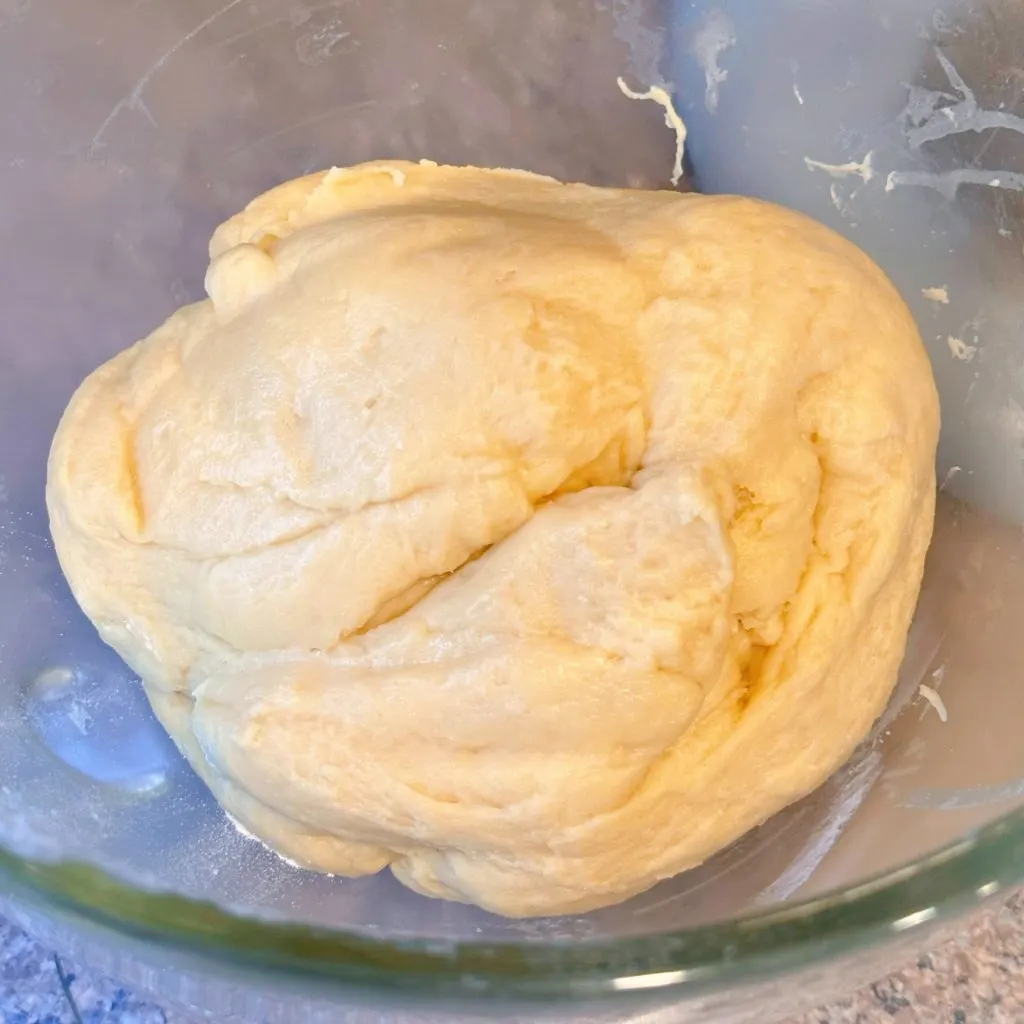 Sweet bread dough formed into a ball in the mixing bowl.