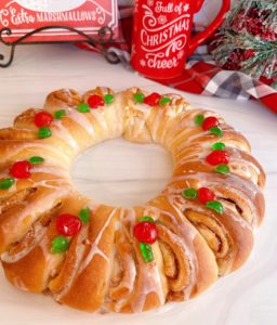 Swedish Tea Ring on a white board with beautiful decorations and a vanilla glaze.