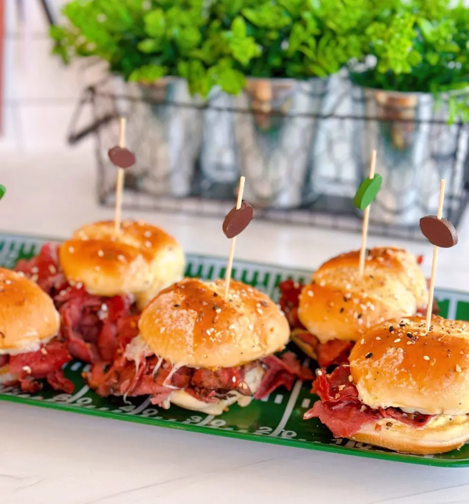 Pastrami sliders on a football platter with cute football picks holding them together.