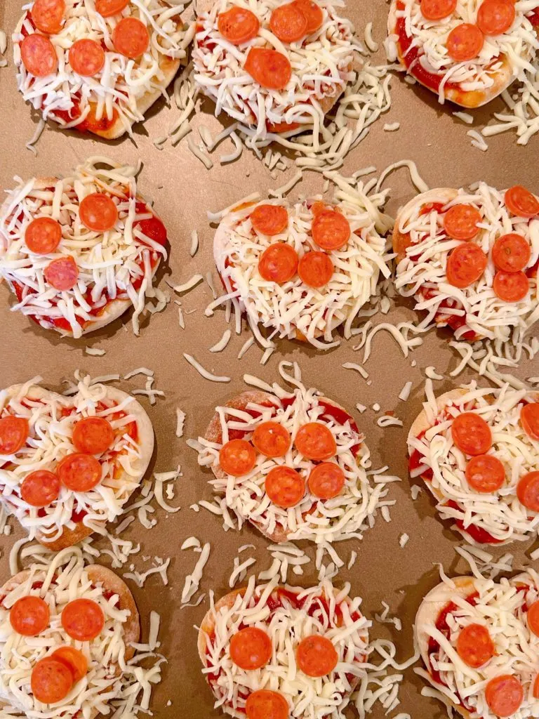 Pizzas topped with shredded cheese and mini pepperoni.