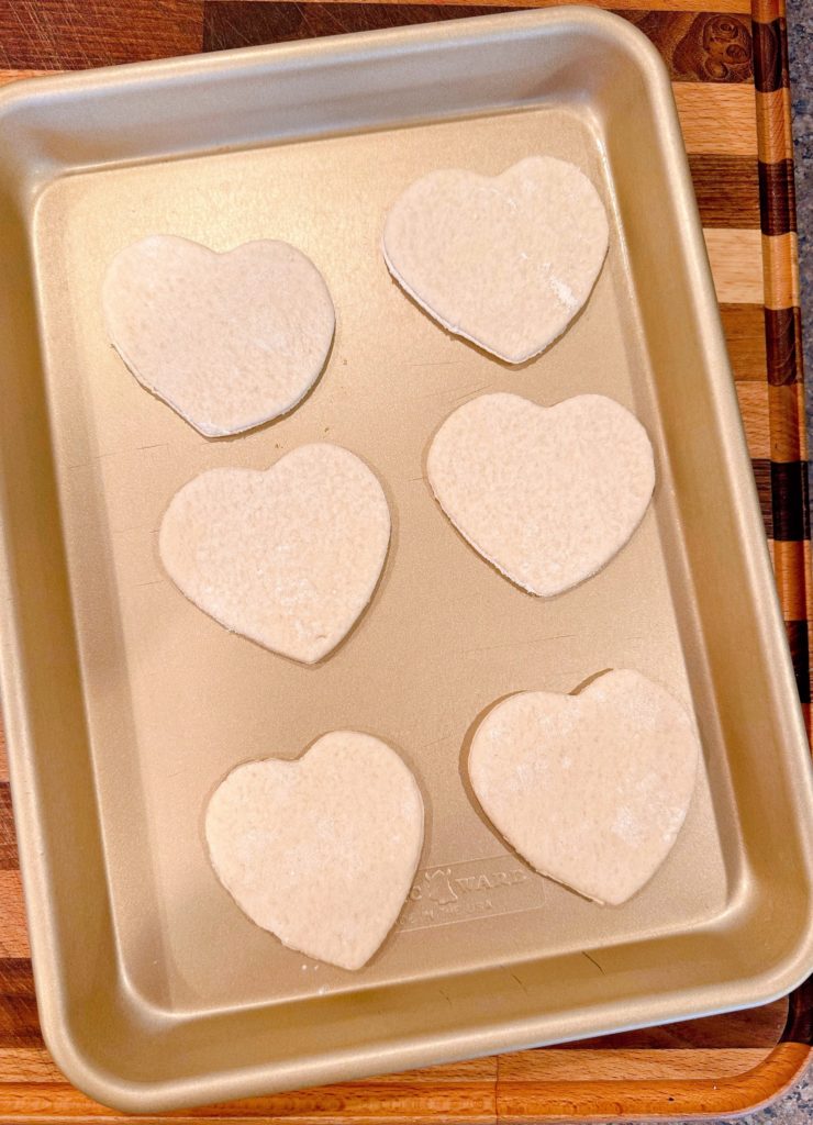 Pizza crust cut into hearts and laid on a small cookie sheet.