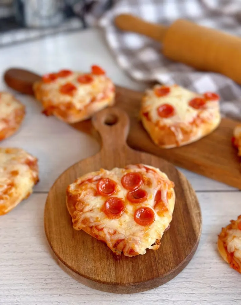 Baked Pizzas on mini cutting boards ready to eat.