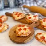 Mini-heart-shaped pizzas on small cutting boards.
