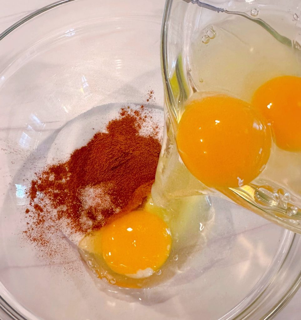 Combining eggs, sugar, and cinnamon in a medium bowl.