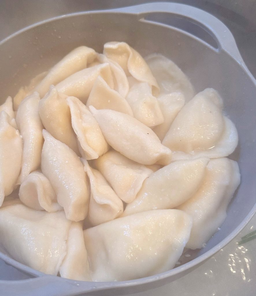 Potato cheese Pierogi in a boiling pot of water.