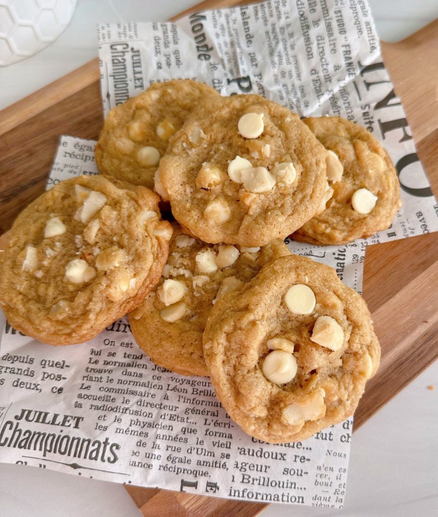 Pile of White Chocolate Chip Macadamia Nut Cookies on a cutting board.
