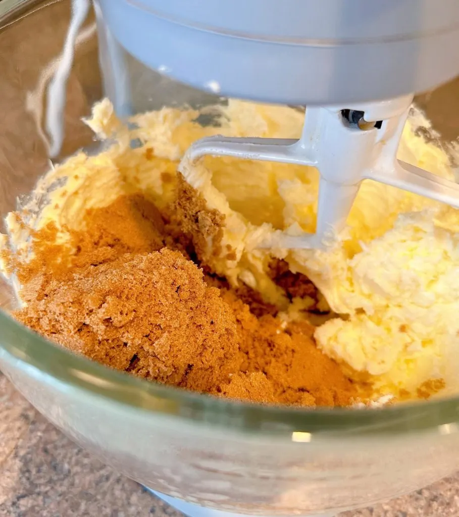 Adding brown sugar and granulated sugar to creamed butter.