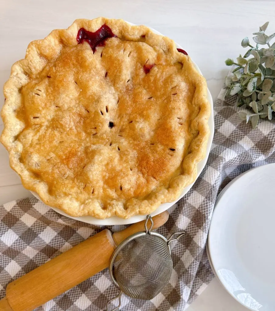 Baked Blackberry Pie on a table with a rolling pin.