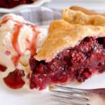 Close-up photo of slice of Blackberry pie with ice cream.