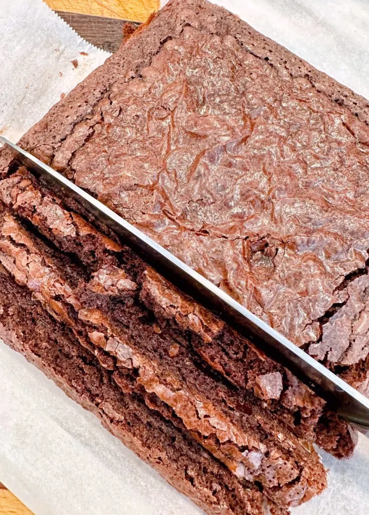 Cooled brownies being cut into ½ inch squares.