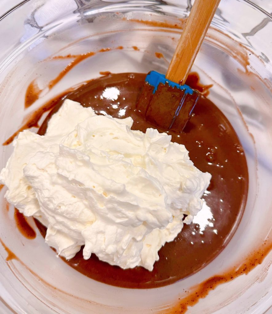 Adding whipped cream to pudding mixture.