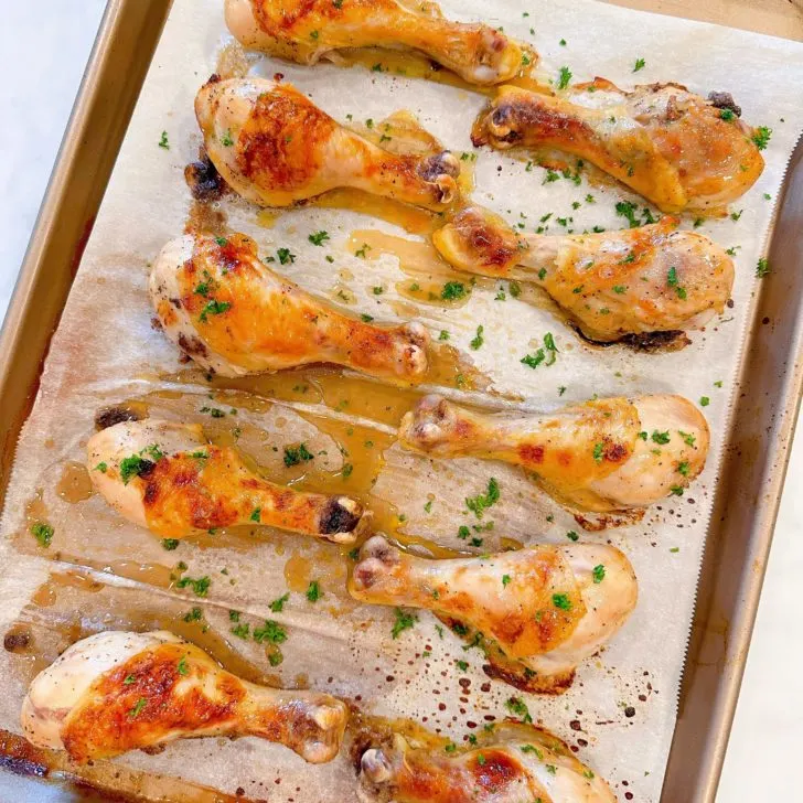 Chicken Drumsticks on a baking sheet with parchment paper baked to a golden brown.