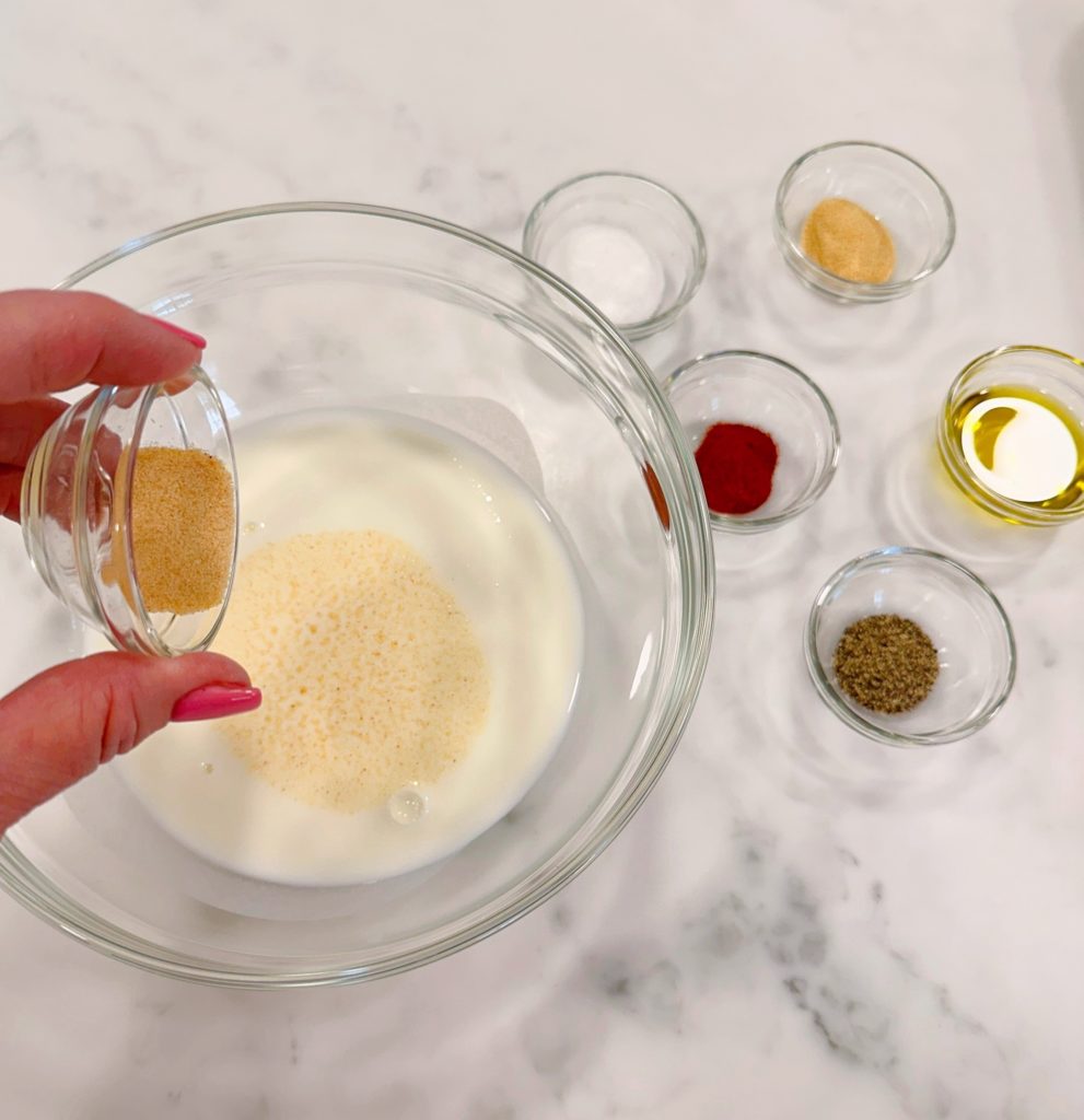 Adding seasonings to the buttermilk for marinade.