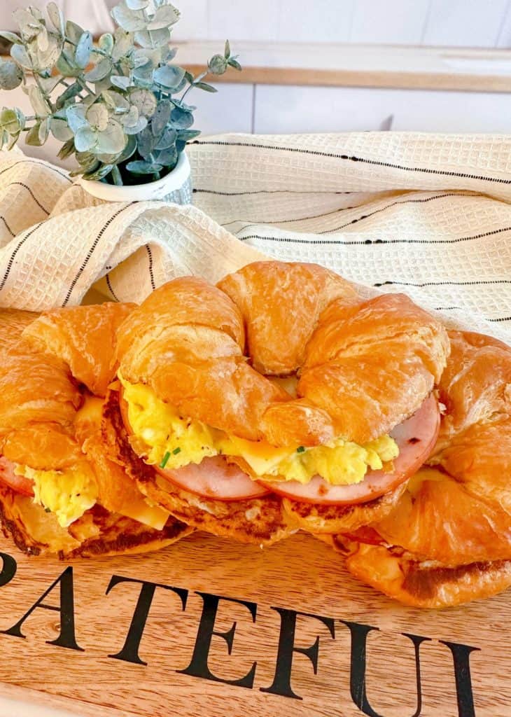 Easy Croissant Breakfast Sandwiches on a cutting board.