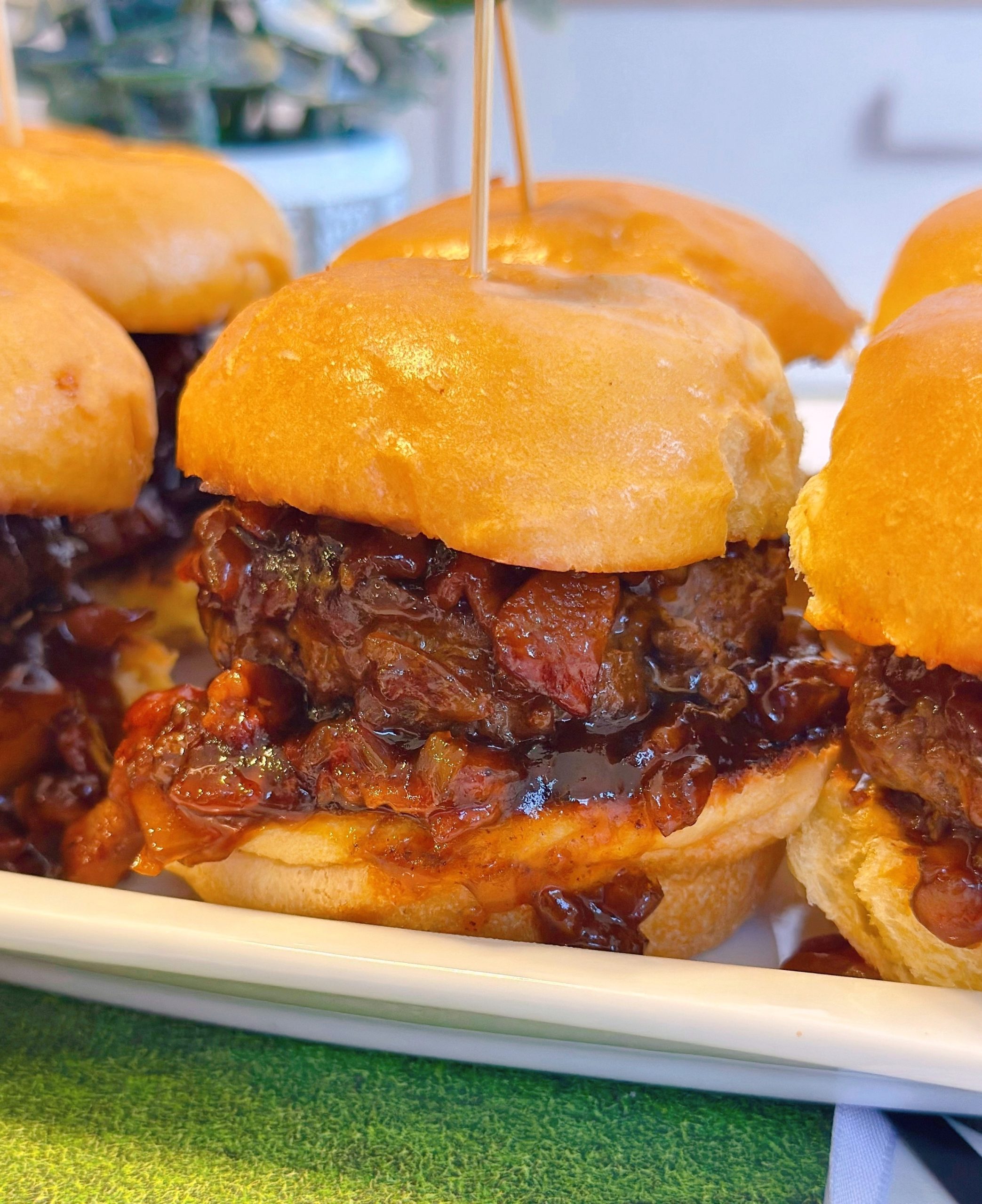 Whiskey Bacon Onion Sliders up close with lots of Bacon burger sauce.