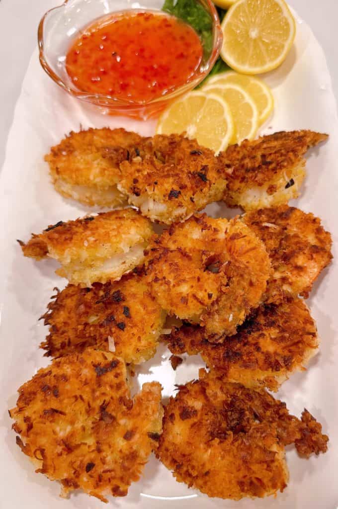 Coconut Shrimp with lemon slices on a white serving platter.