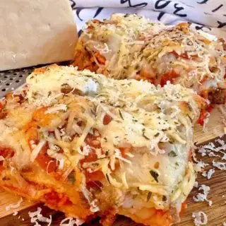 Deep Dish pizza cooked an on a wooden cutting board.